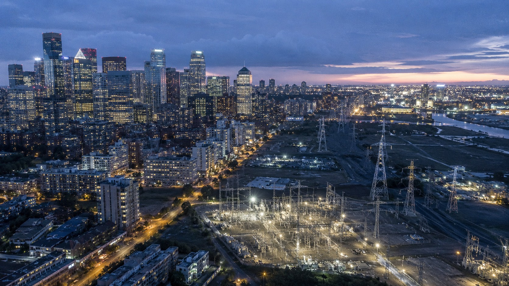 A financial-district skyline meeting an illuminated power grid